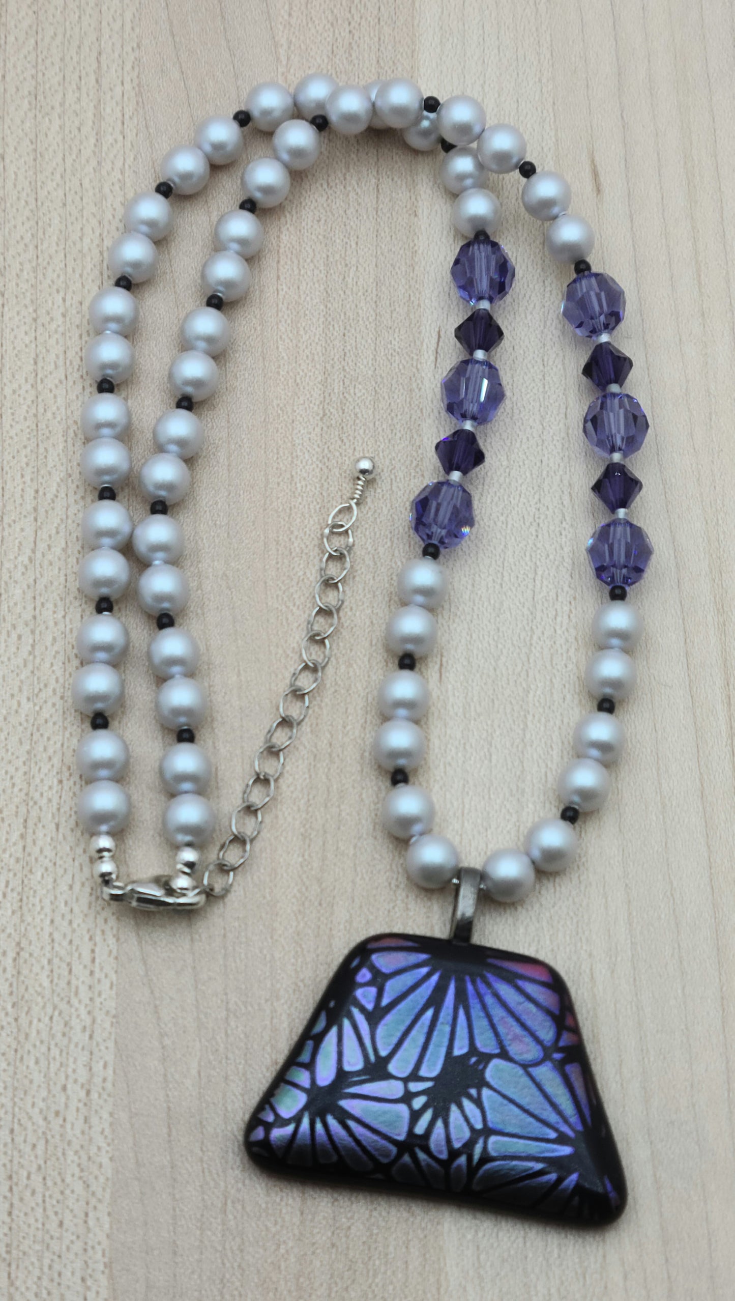 The lovely bluish violet flowers in this etched dichroic glass pendant (by amwh) are matched in the accompanying crystals & the complimented by the silver crystal pearls.