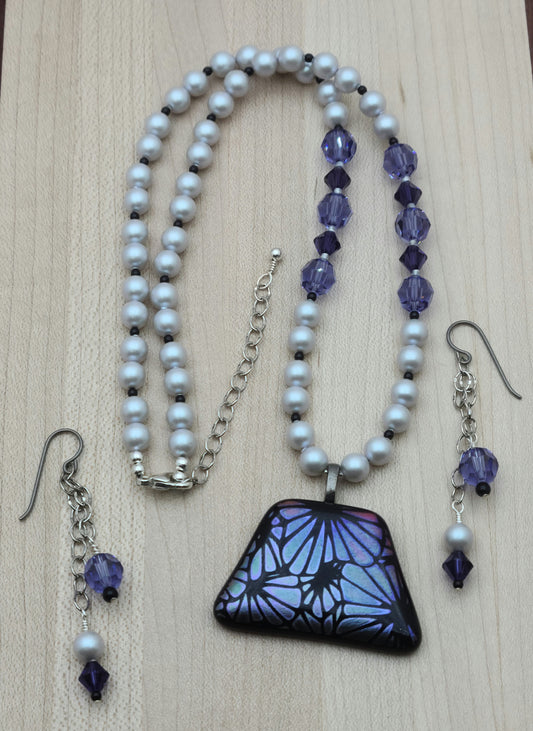 The lovely bluish violet flowers in this etched dichroic glass pendant (by amwh) are matched in the accompanying crystals & the complimented by the silver crystal pearls.