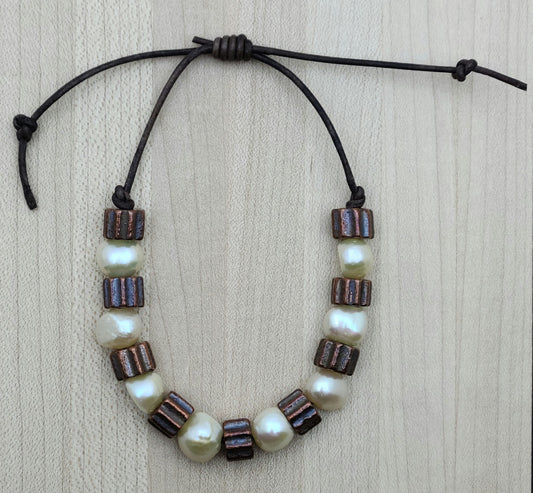 A casual leather slider bracelet of baroque freshwater in ccream and antique copper plated ceramic.