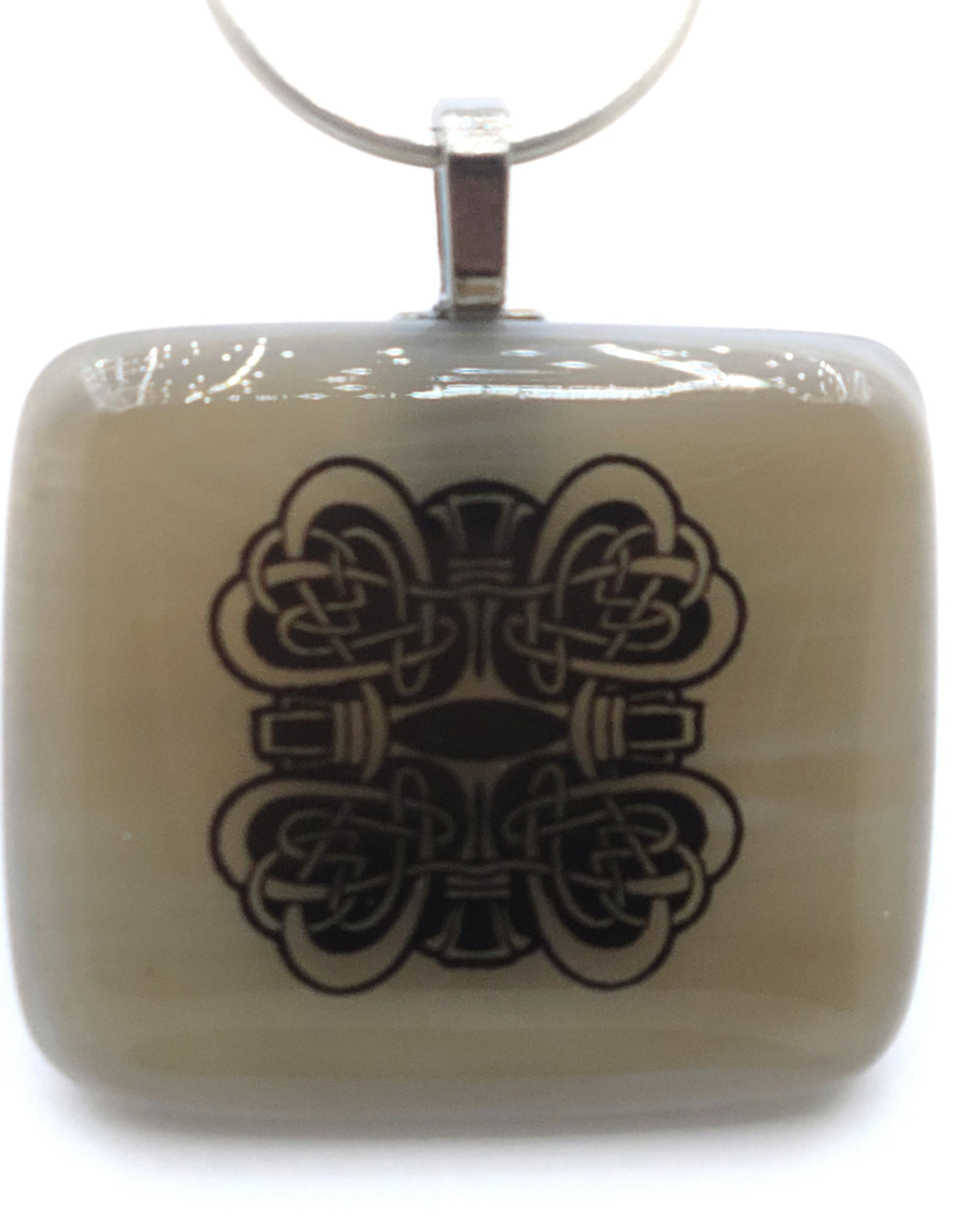 Celtic knotted hearts ornament this light tan fused glass pendant.