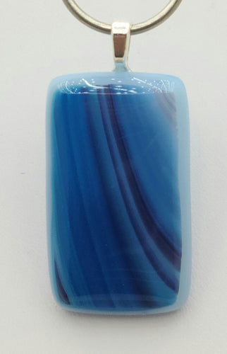 Light to dark hues of blue stretch down this rectangular fused glass pendant.