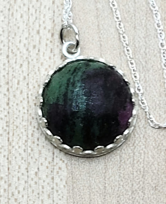 This Ruby in Zoisite Drop features a beautiful fusion of red ruby and green zoisite, set in a detailed sterling silver bezel.