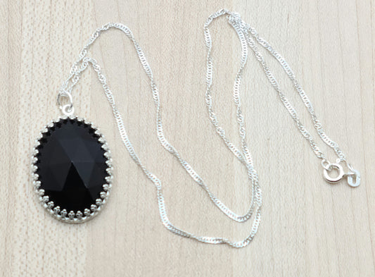 This Oval Faceted Onyx Drop, set in sterling silver, will add a touch of elegance to any outfit.