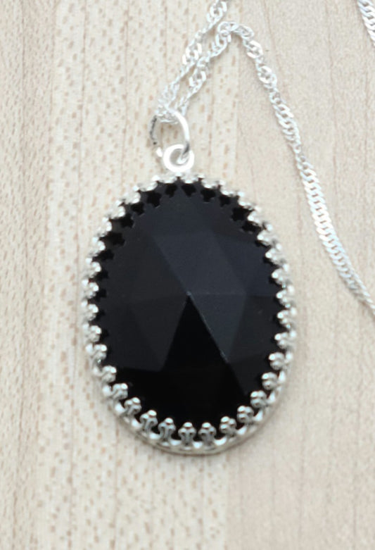 This Oval Faceted Onyx Drop, set in sterling silver, will add a touch of elegance to any outfit.