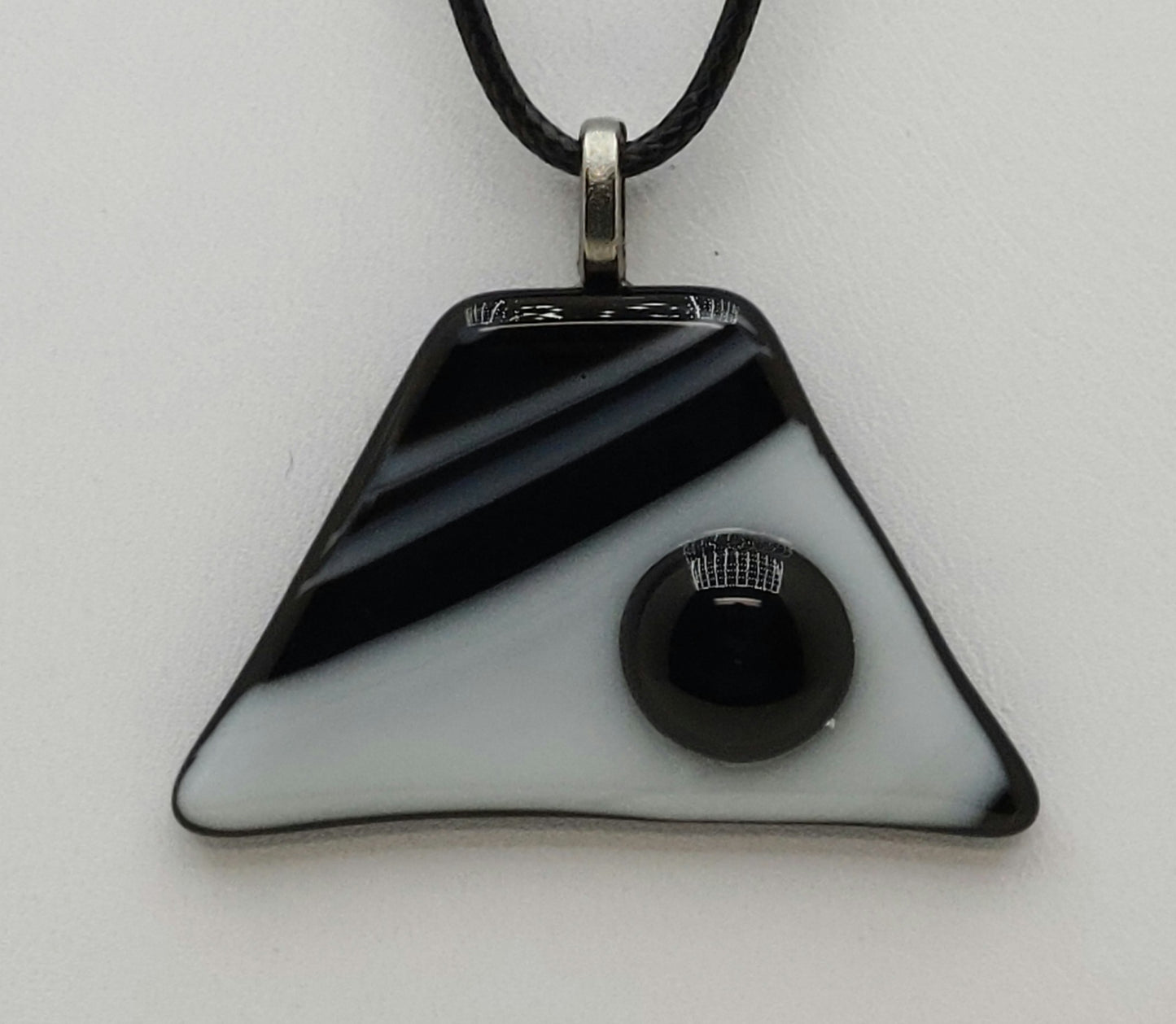 black 'pebble' on black & white background trapezoid fused glass pendant