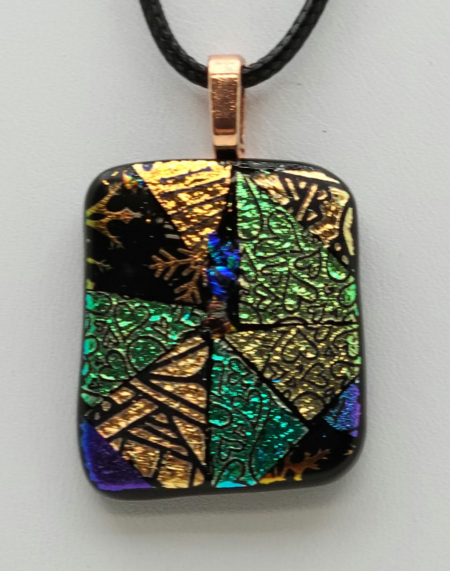Here's a fun patchwork fused glass pendant of pieces of etched dichroic glass!