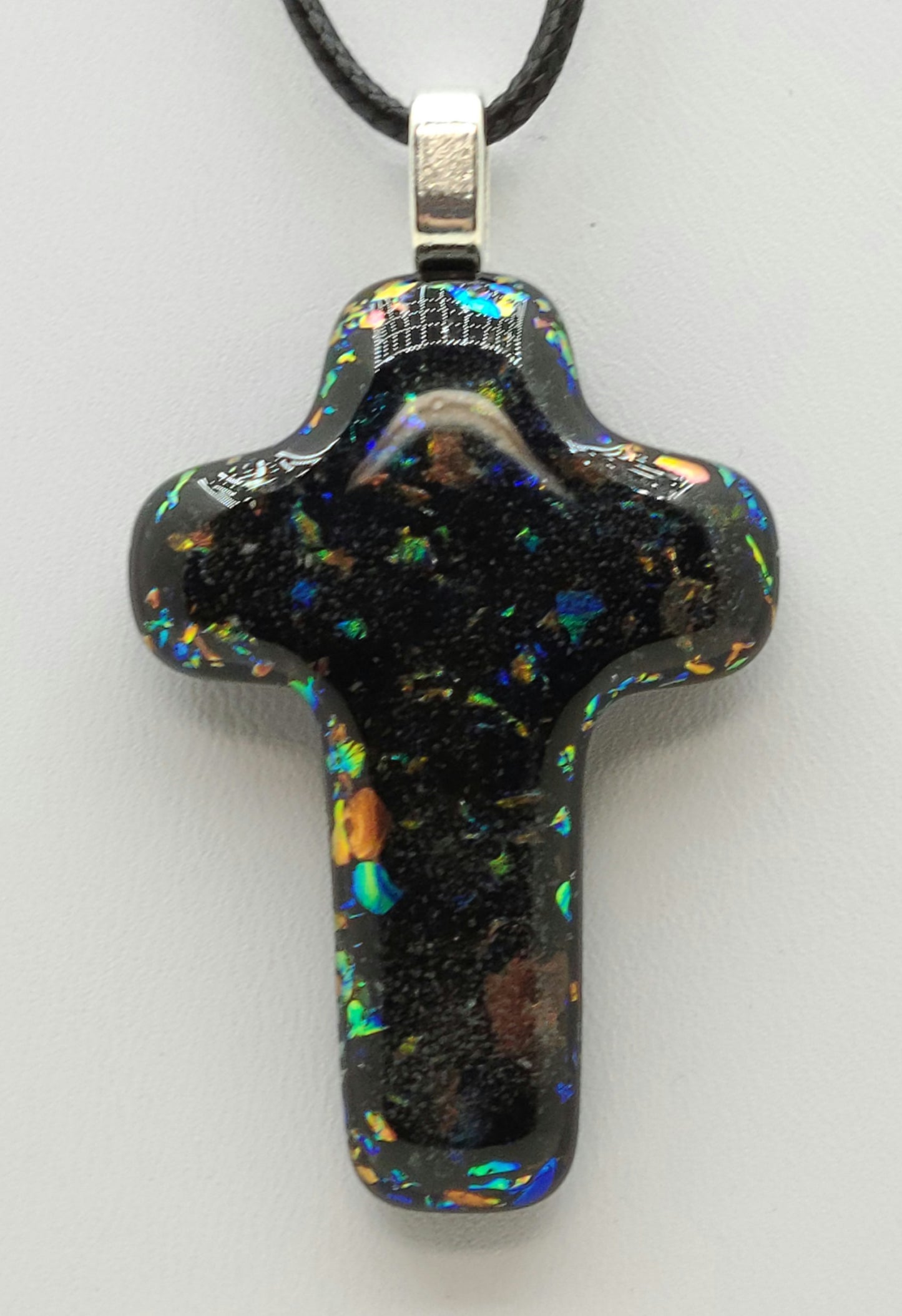 dichroic glass flecks peak through in the fused glass cross pendant.