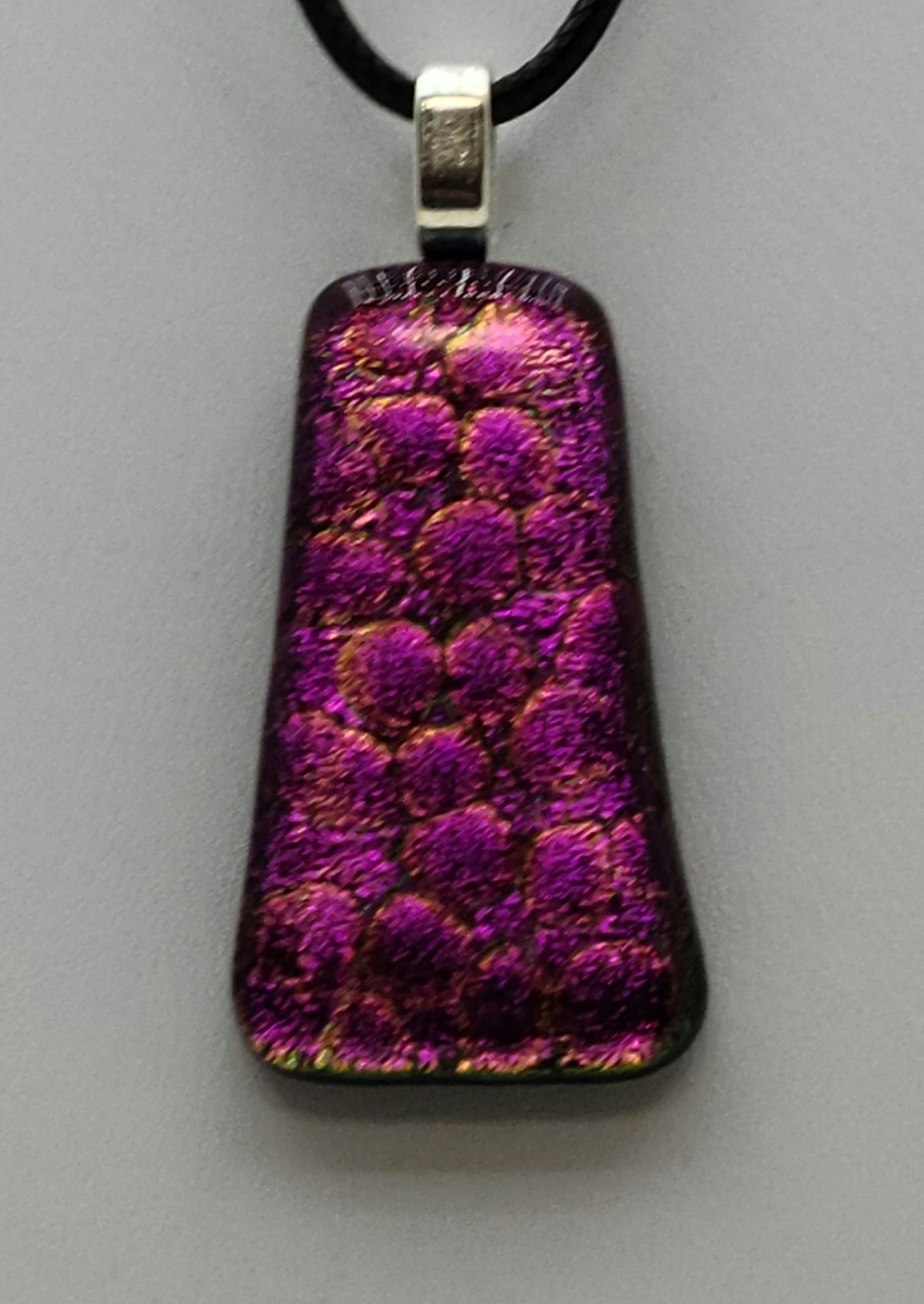 This dichroic fused glass pendant is like looking at fuchsia pebbles through clear water!