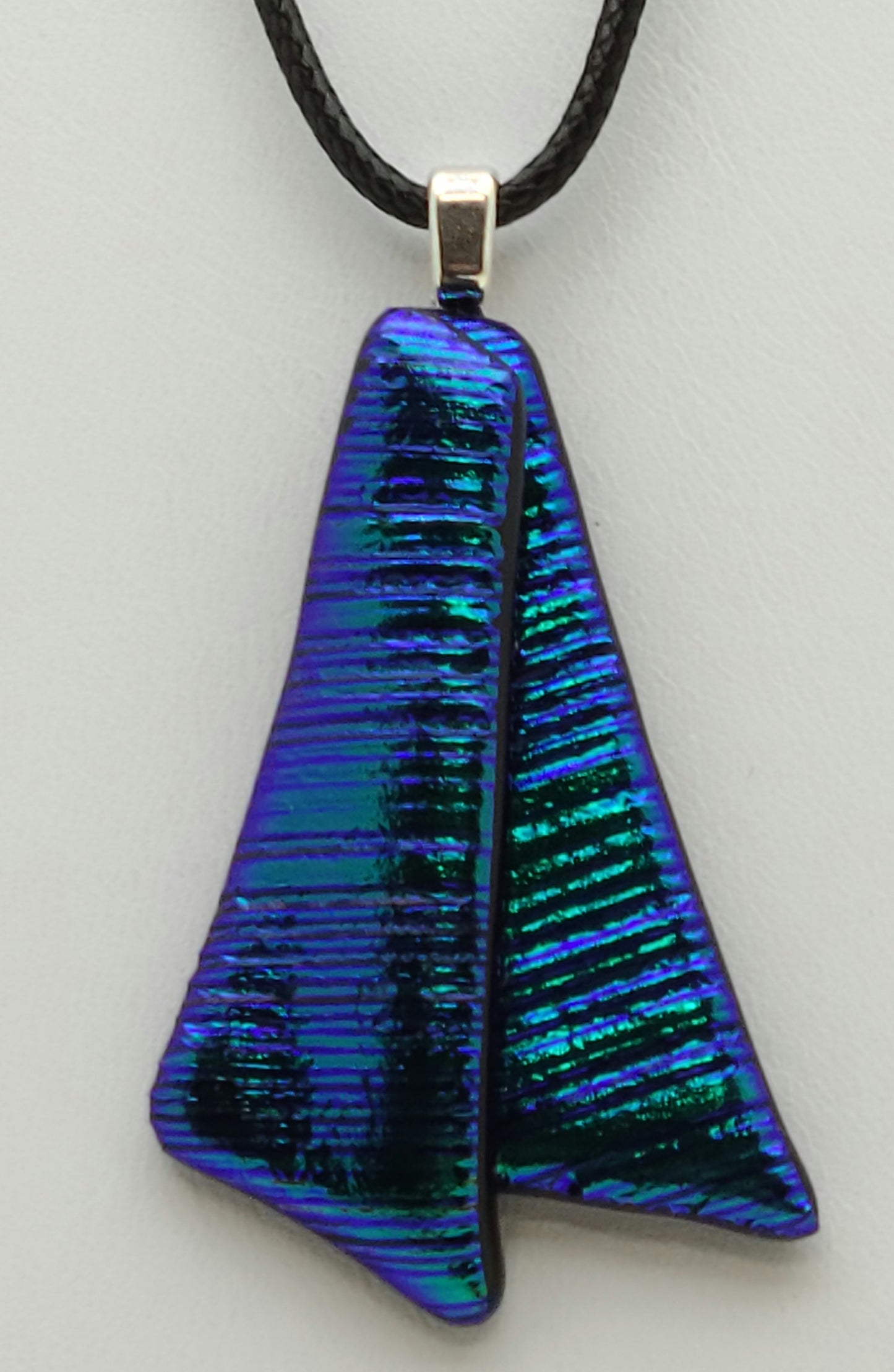 Ribbon tails of deep teal with hints of purple & green in a beautiful dichroic fused glass pendant.