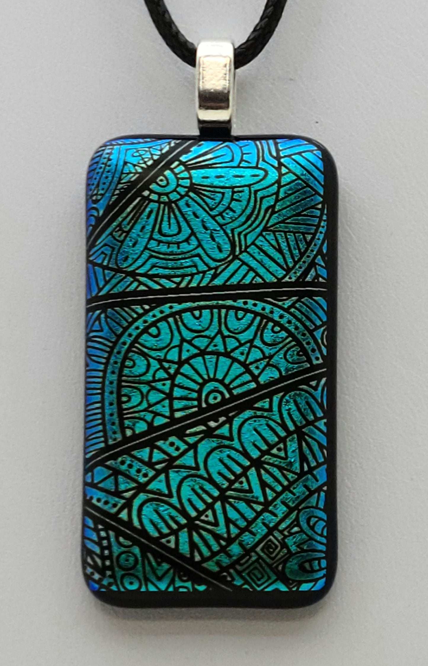 modern free-style designs adorn this blue green dichroic fused glass pendant.