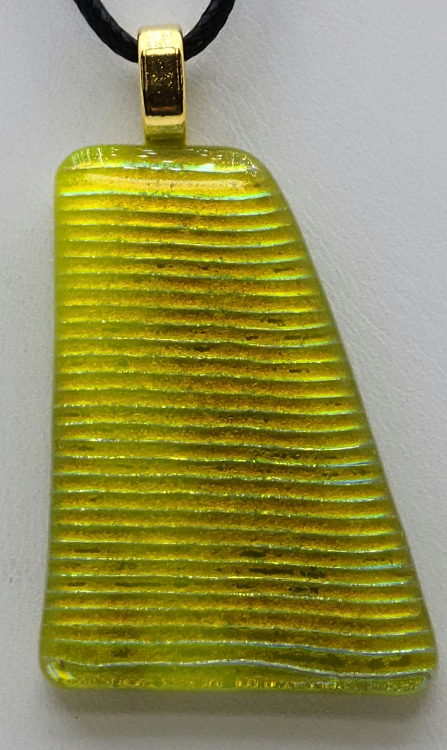 The beautiful gold of a rising sun shines in this dichroic fused glass pendant.