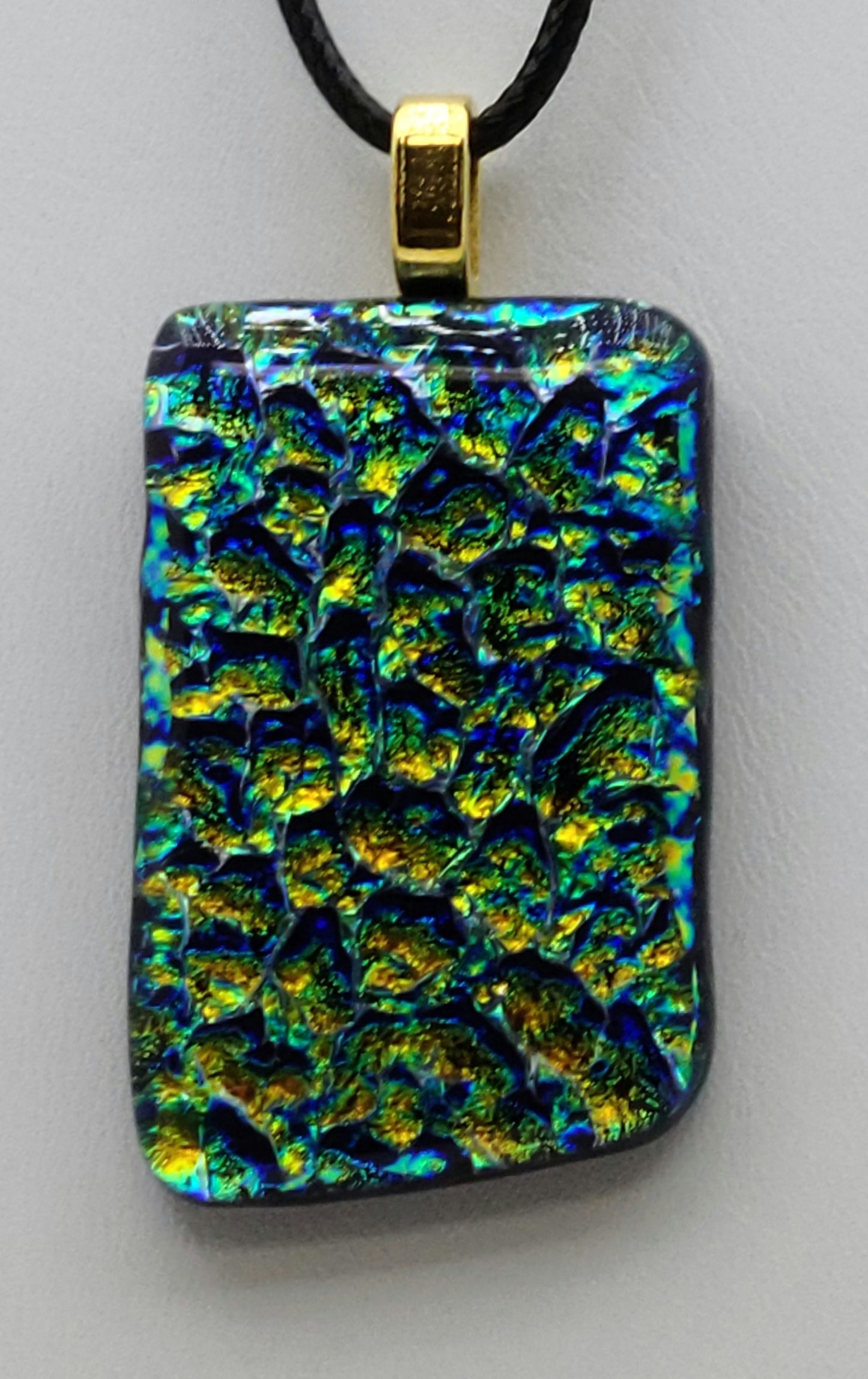 Bubbles of blue, green, & gold effervesce in this dichroic fused glass pendant.