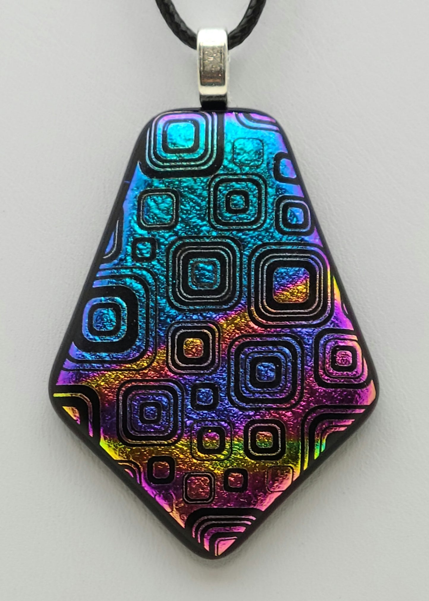 A plethora of concentric boxes are etched into rainbow dichroic glass in this pendant.