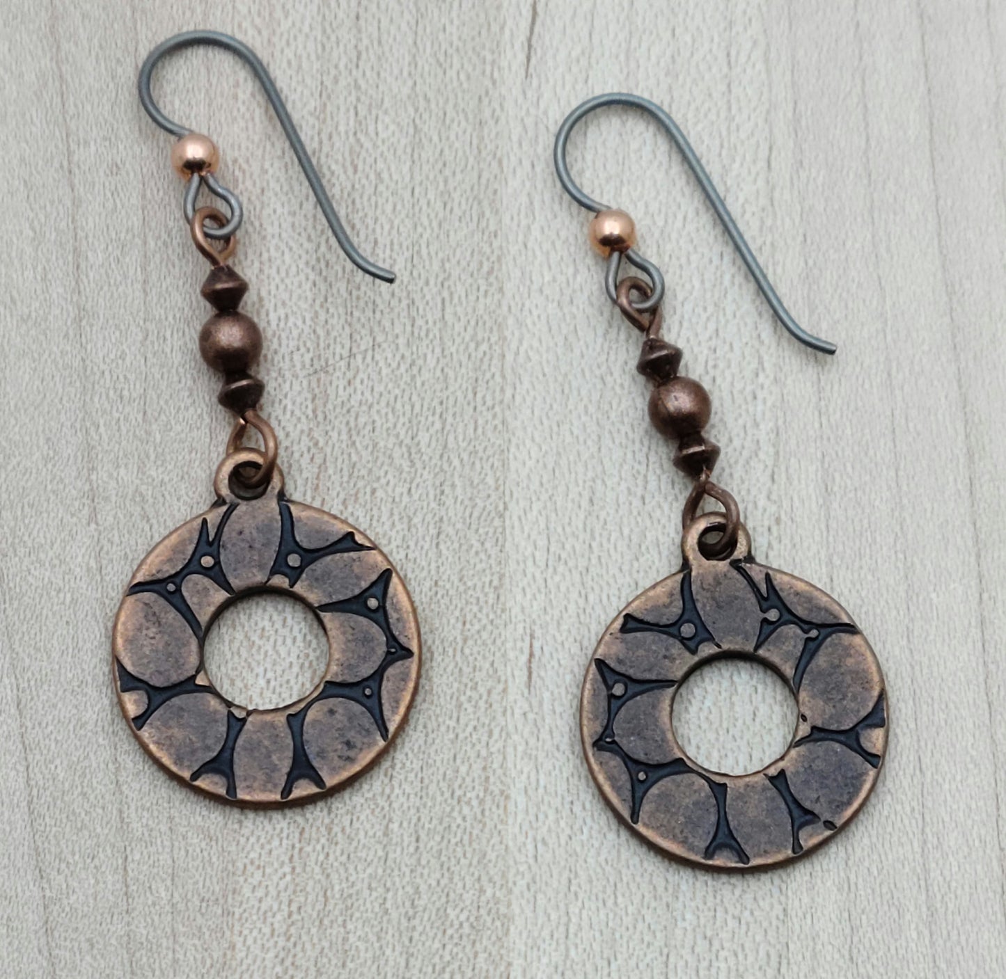Add a playful spin to your look with these Copper Wheel Earrings. Antique copper beads hold charming embossed ‘wheels’ that sway with every move, bringing a fun, dynamic touch to any outfit.