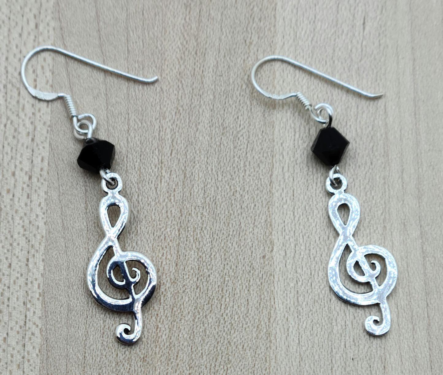 sterling silver treble clefs hang from black crystals and sterling silver fish hook ear wires