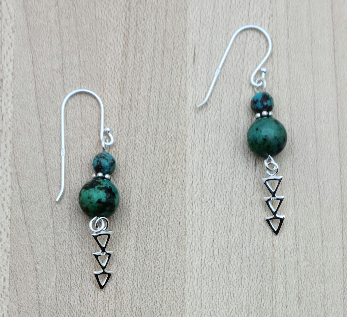 African turquoise beads host dangling geometric sterling silver designs in these Earrings with sterling silver fish hook ear wires.