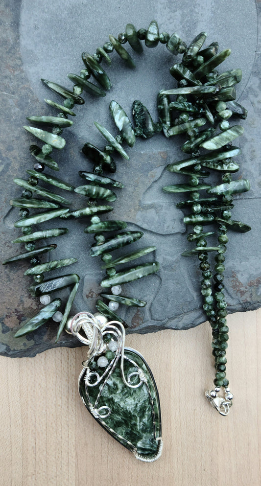 a seraphinite cabochon is framed in woven silver filled wire and hangs from necklace of seraphinte freeform spikes.