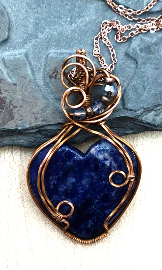 This delightful blue sodalite heart pendant is your ticket to speaking with confidence and creativity! Wrapped in warm antiqued copper wire, the Poet's Stone activates your throat chakra to help you express yourself authentically.