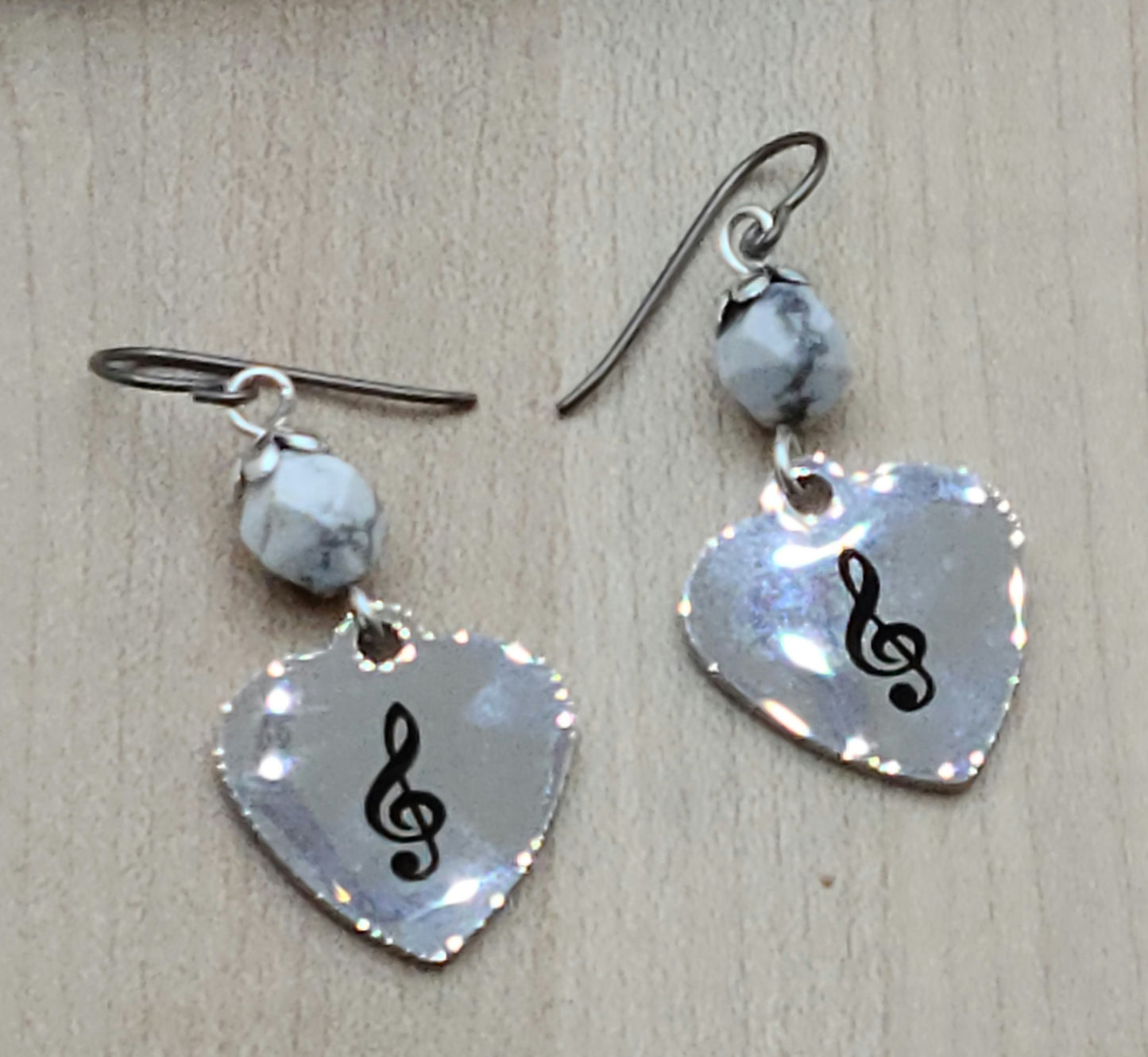 Love music? Play a treble clef instrument? Then these stainless steel hearts displaying a treble clef are for you! For added interest they hang from capped, faceted howlite beads.