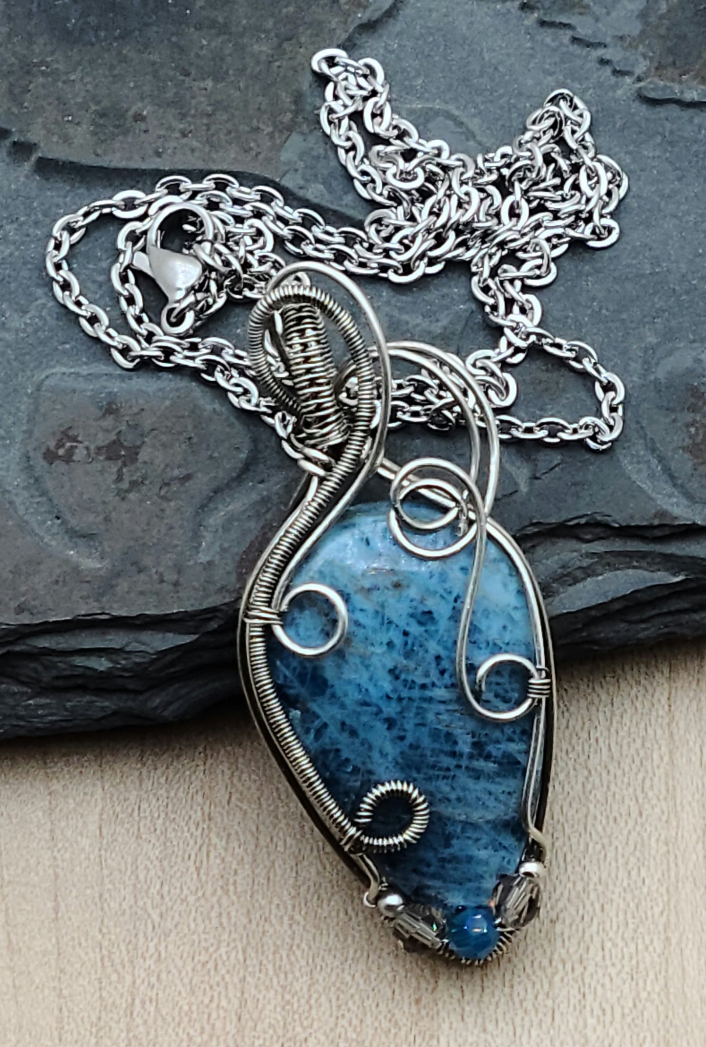 Lovely blue apatite teardrop cabochon framed with antique silver filled woven wire in swirling patterns.