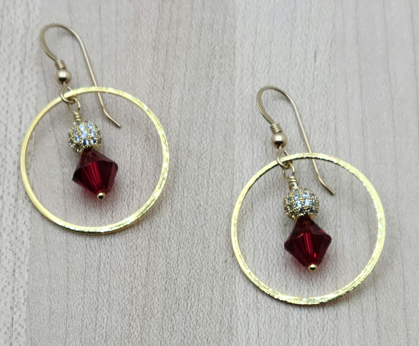 Scarlet crystals, CZ encrusted shamballa beads, and gold plated rings hang from gold filled fish hook ear wires in the beautiful earrings.