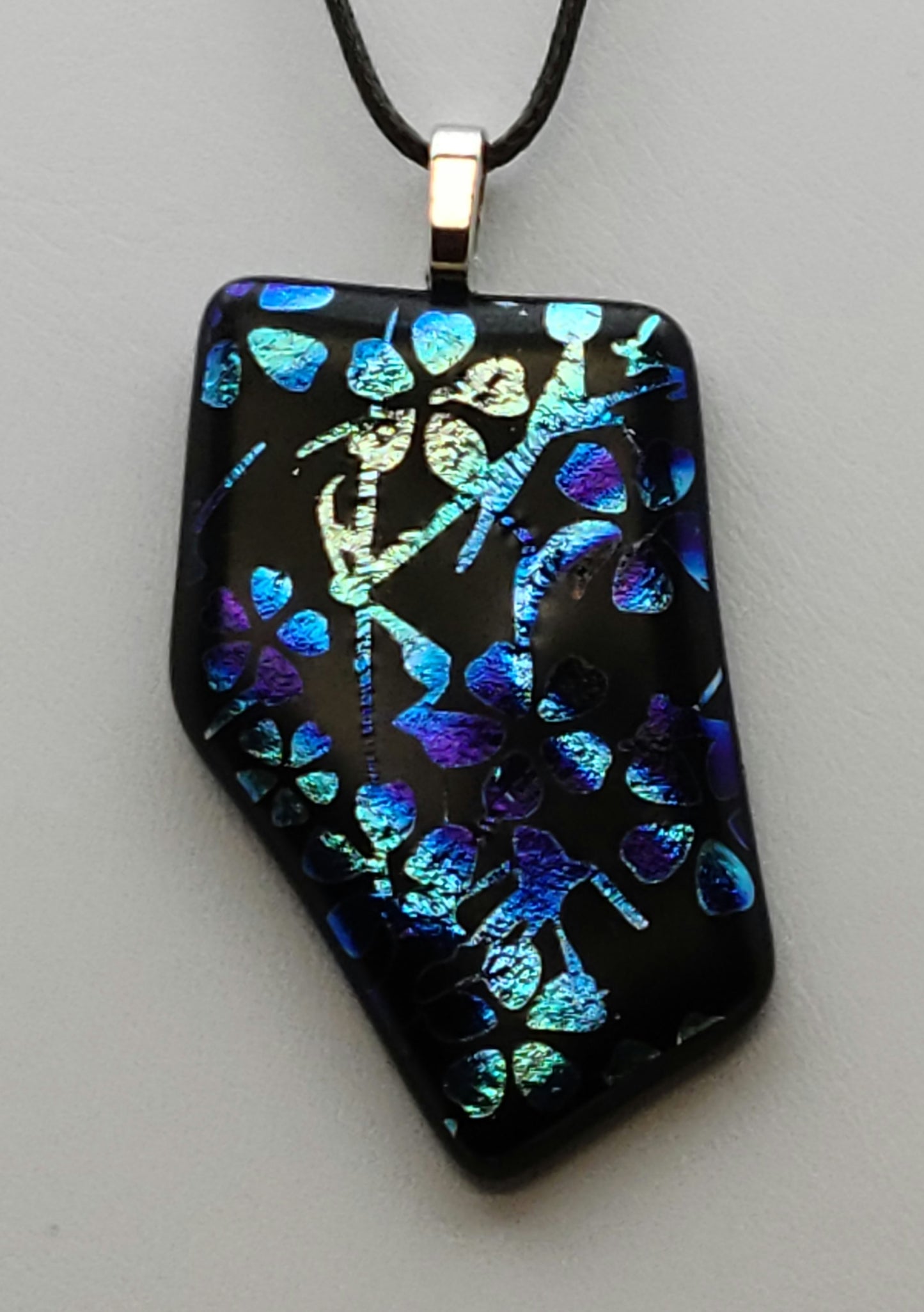 Add a touch of whimsy to your outfit with our Blue & Silver Blossoms Fused Glass Pendant.