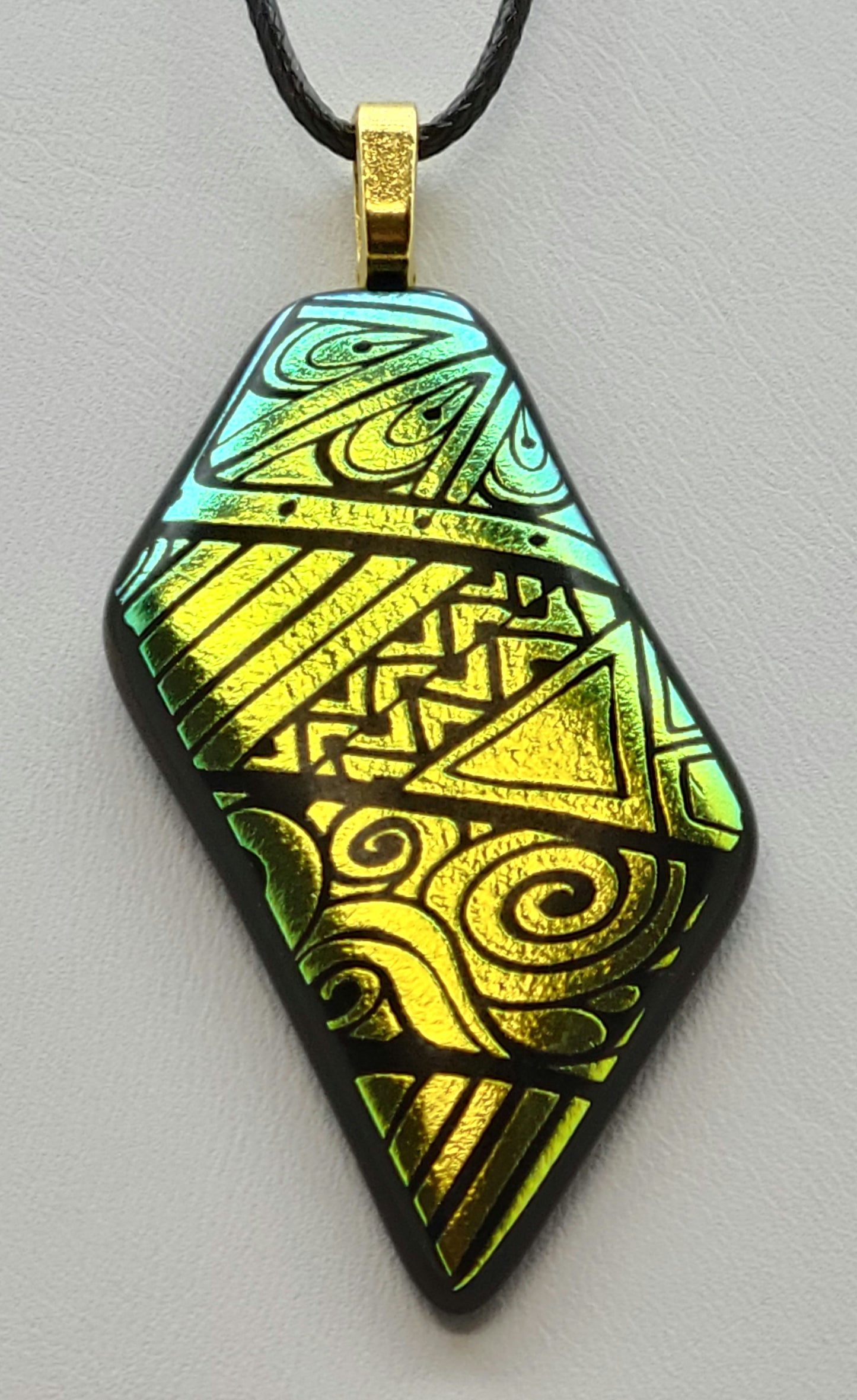 Expertly crafted from fused glass, the On Point pendant features bold geometrics etched in vibrant gold dichroic glass.