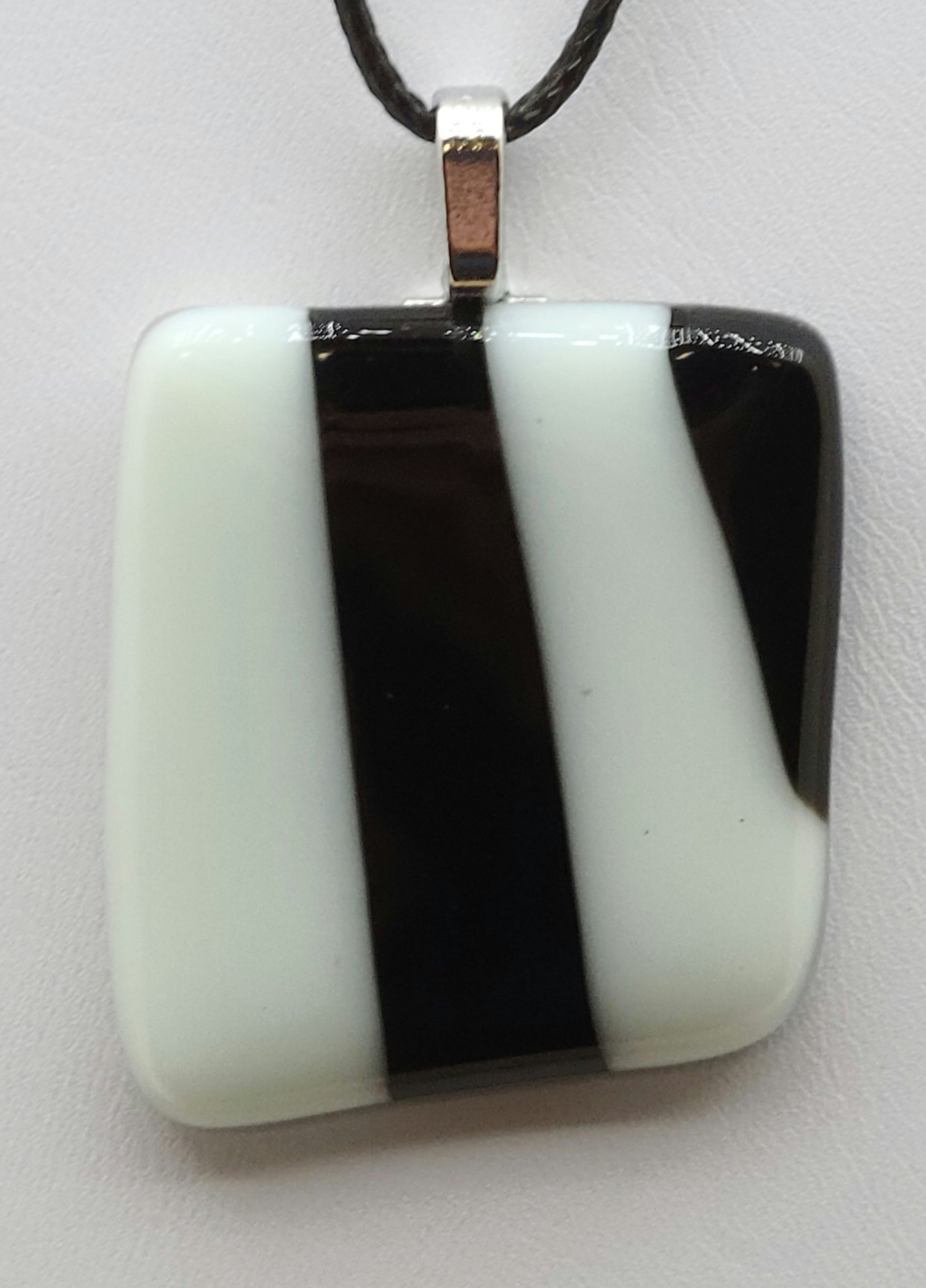 Add a touch of elegance to your wardrobe with our White w/Black Stripe Fused Glass Pendant.