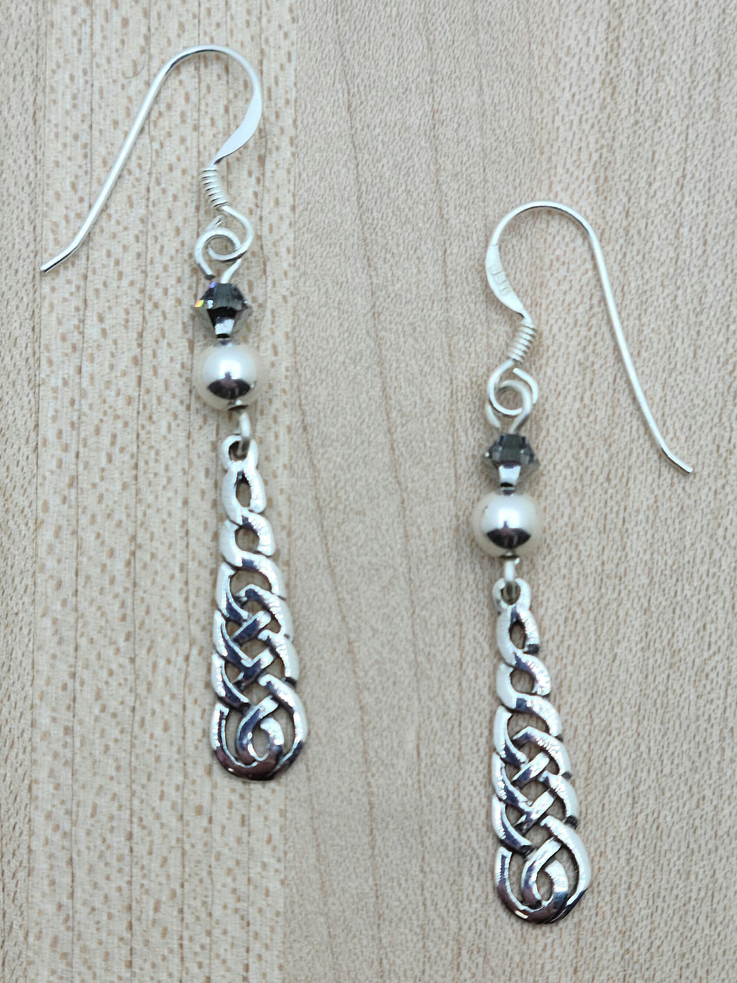Silver crystals & crystal pearls host sterling silver endless weave pendants.