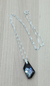 A large modern crystal pendant, dark grey with cool undertones, makes this crystal necklace both sophisticated & elegant.