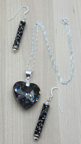 This beautiful crystal heart is a compliment to any attire and will always be admired! The focal is a large, dark grey, yet sparkling crystal heart pendant with sterling silver bail & chain & crystal rock tube earrings
