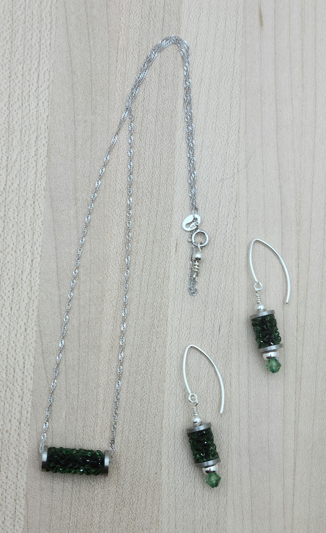 So simple, yet eye catching! The focal is a tube comprised of erinite green crystal 'rocks' on a sterling silver chain. & fish hooks