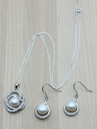 This lustrous white freshwater pearl necklace's pearl is framed by swirls of cubic zirconia encrusted sterling silver. The earrings also feature FW pearls & CZs.