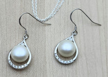 These lustrous white freshwater pearl fish hook earrings are framed by teardrops of cubic zirconia encrusted sterling silver.