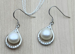 These lustrous white freshwater pearl fish hook earrings are framed by teardrops of cubic zirconia encrusted sterling silver.