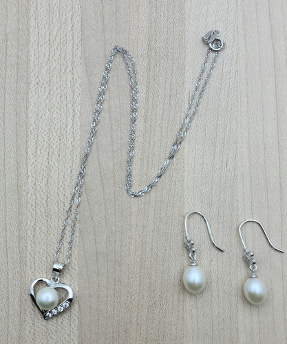 In this dainty pearl necklace, a lovely white pearl nestles in a sterling silver heart adorned with cubic zirconia. Teardrop pearl earrings with CZ fish hook earrings.