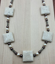This necklace's focal beads are large river stone "pillows." They are complimented by bali spacers, velvet brown & cream crystal pearls & translucent brown crystals! 