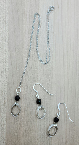 Crystal oval rings in a barely silver shade contrast with jet black crystals in this lovely necklace & earring set.