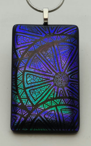 Do you see a citrus slice or a wheel? Regardless, this etched dichroic design in bright blue, purple, & green is a definite statement piece!
