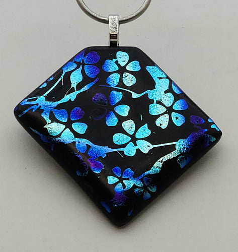 Branches full of delightful blossoms are etched in blue & silver dichroic glass on this lovely, sure to be noticed, fused glass pendant!