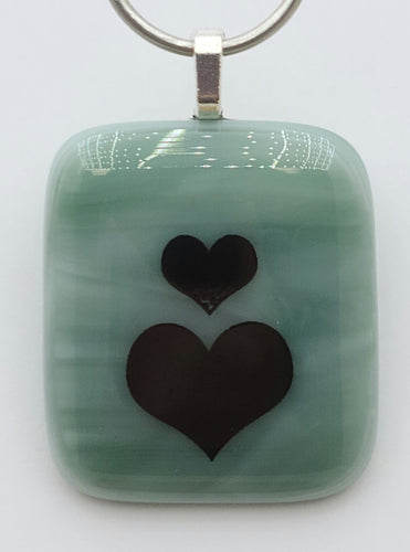 A fused glass pendant with twice the love with double hearts on streaky tiffany blue!
