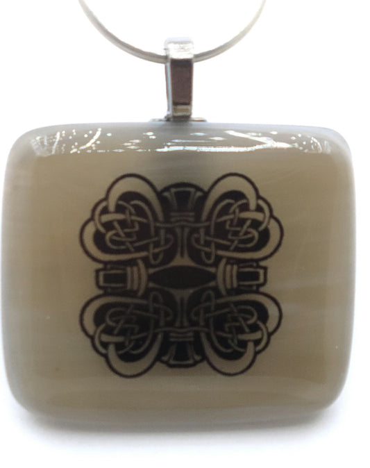 Celtic knotted hearts ornament this light tan fused glass pendant.