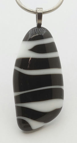 A fused glass pendant featuring zebra stripes!