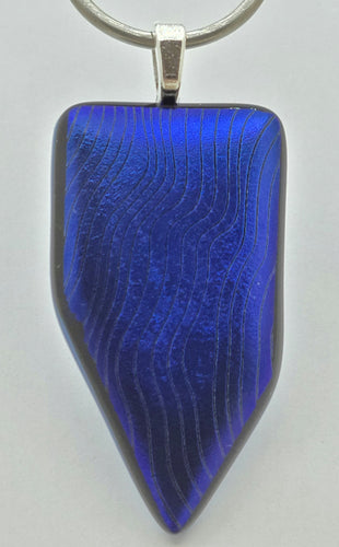 Wavy lines etched into deep sapphire blue dichroic glass create an interesting pattern in this fused glass pendant!
