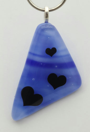 The clear cap over pretty blues causes the hearts to seem to hover over the fused glass pendant!