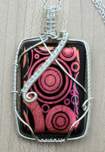 Tarnish resistant silver plated copper wire around one of my fused glass pendants of etched dichroic glass with fun red circles.