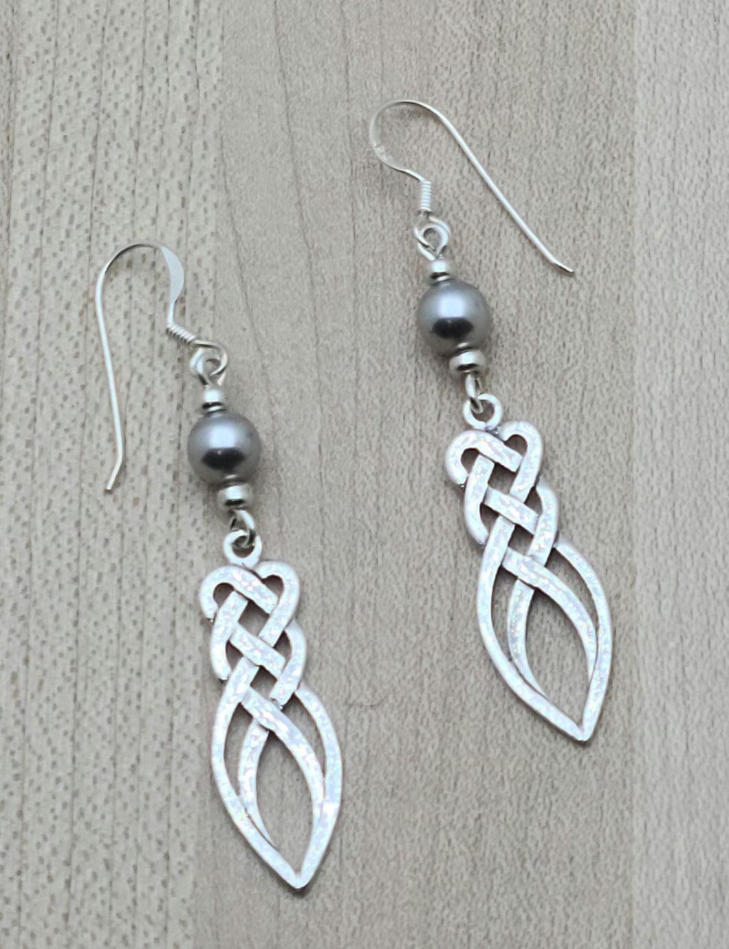 Silver crystal pearls* host a sterling silver endless weave knot in  these versatile earrings.