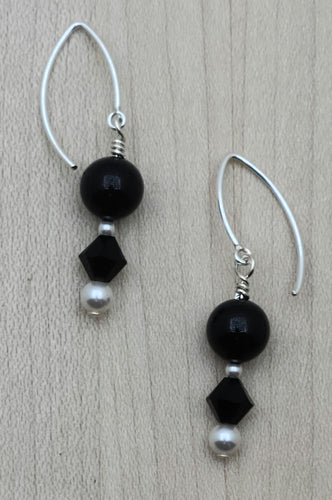 The black crystal pearls and crystals are complemented by small white crystal pearls, all hanging from elegant sterling silver fish hook ear wires.