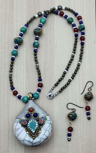 Make a statement with our Large Napalese Pendant & Earring Set featuring brass, shell, turquoise, coral, and lapis.