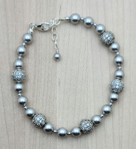 Elevate your style with our Silver CZ Shamballa Bracelet. The combination of silver crystal pearls and cubic zirconia encrusted shamballa beads creates a sophisticated look. 